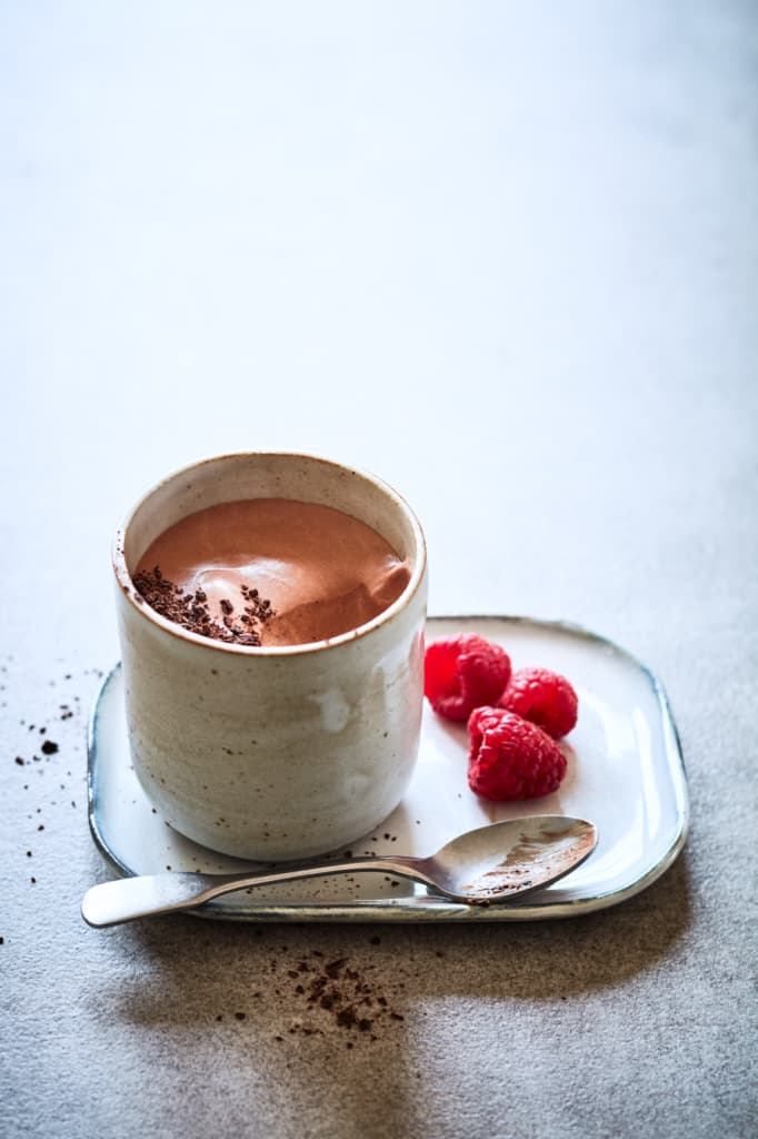 Chocolate mousse in a mug with a spoon