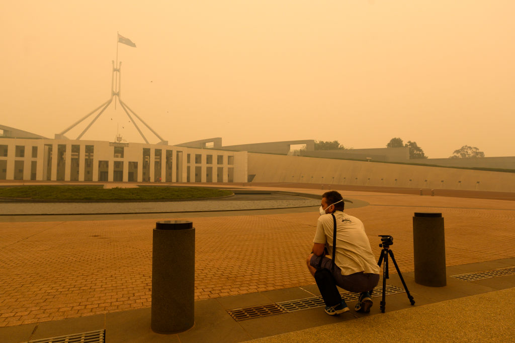 CANBERRA, AUSTRALIA - JANUARY 05: A photographer captures smoke at Parliament House on January 05, 2020 in Canberra, Australia. Smoke haze across Eastern Australian cities has become common in recent months as bushfires continue to burn. Hundreds of fires continue to burn in NSW, Victoria and South Australia, with the Australian Defence Force now called in to help with firefighting and rescue efforts. 14 people have died in the fires in NSW, Victoria and SA since New Year's Eve. (Photo by Rohan Thomson/Getty Images