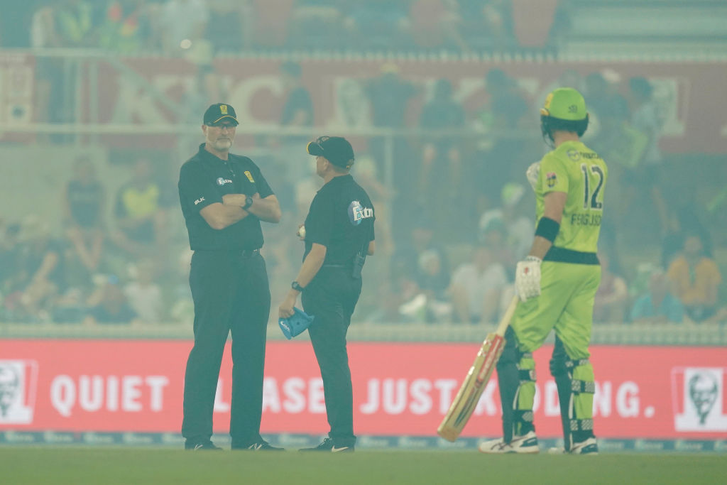 CANBERRA, AUSTRALIA - DECEMBER 21: The Umpires discuss suspending play because of bushfire smoke during the Big Bash League match between the Sydney Thunder and the Adelaide Strikers at Manuka Oval on December 21, 2019 in Canberra, Australia. (Photo by Mark Evans - CA/Cricket Australia via Getty Images )