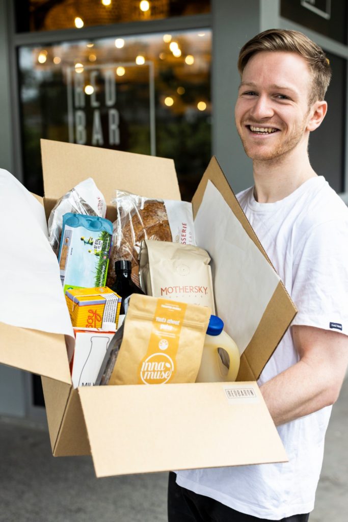 Red Baron owner-operator Daniel Roberts holds takeaway food box for delivery