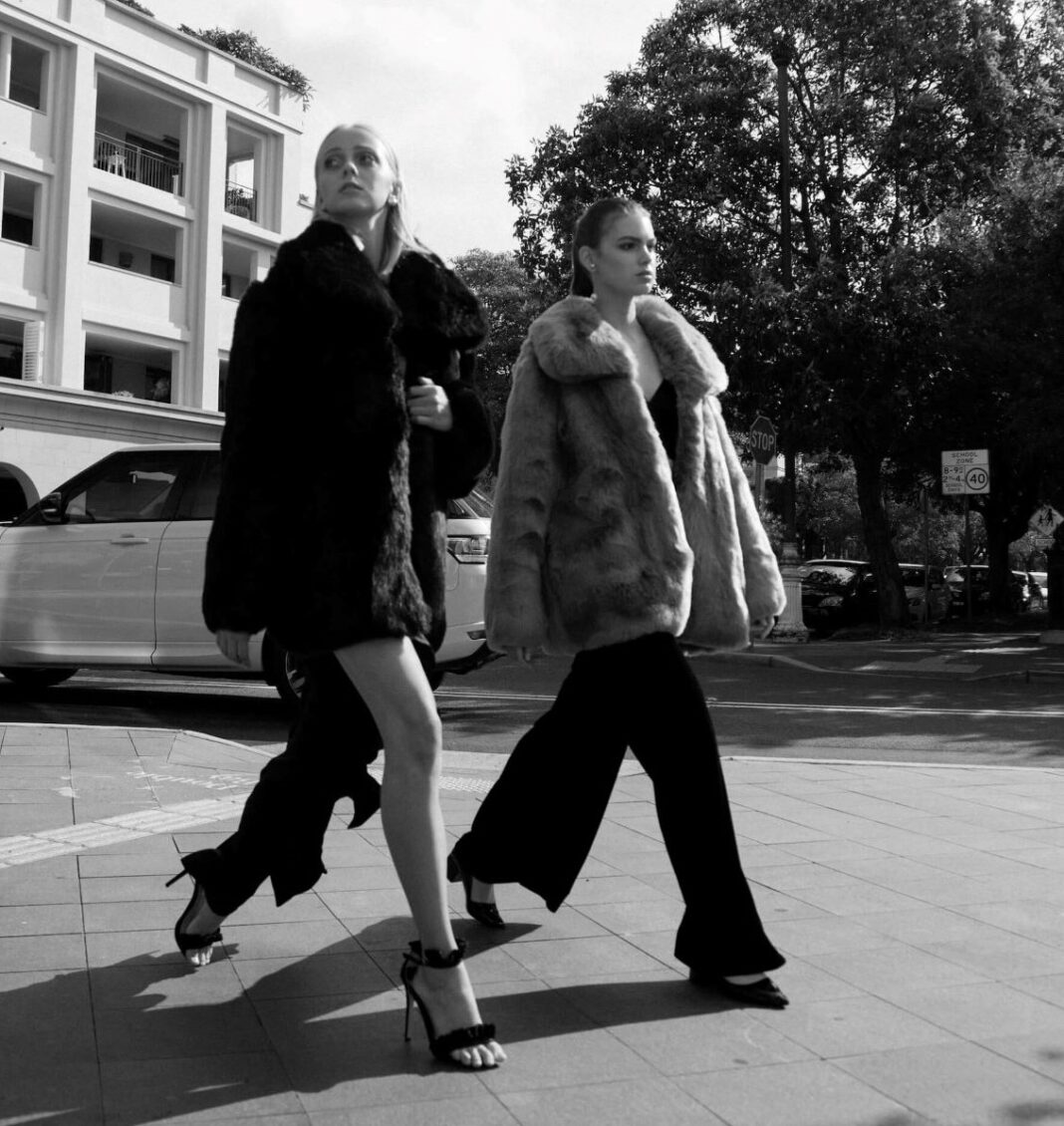 two women walking in large coats
