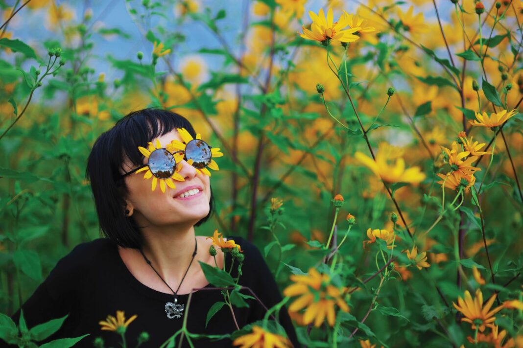 woman wearing flower sunglasses amongst flowers