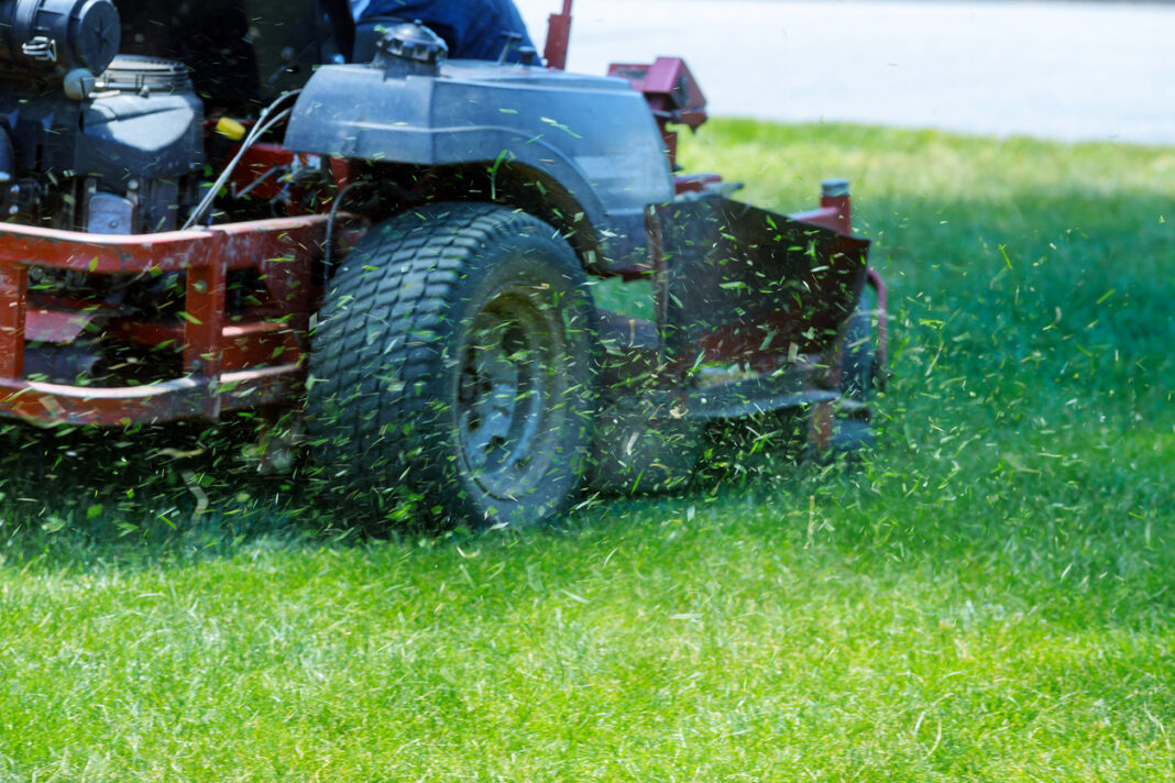 Red Lawn mower cutting grass.