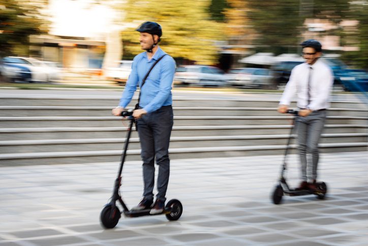 Businessmen riding electric scooter