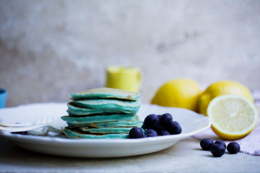 Super blue pancakes on a plate with lemons on the side