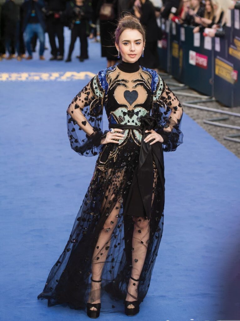 Lily Collins posing for a photo on a blue carpet
