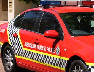 Side-on view of part of a red Australian Federal Police sedan with lights on top