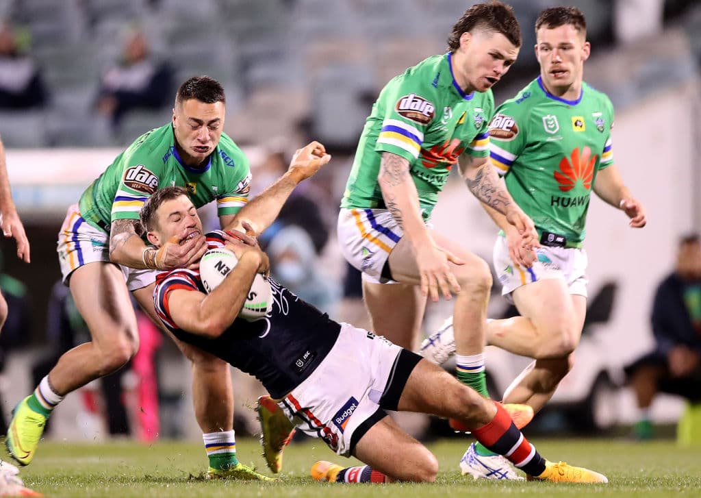 James Tedesco of the Roosters being tackled by the Raiders