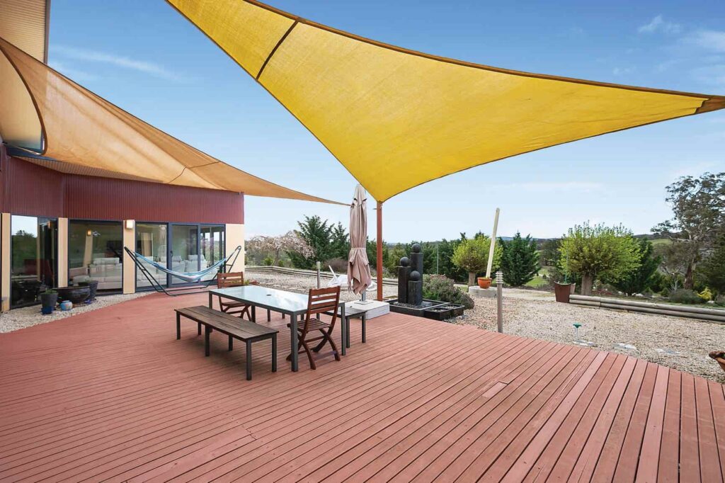 deck of home with large yellow shade cloth