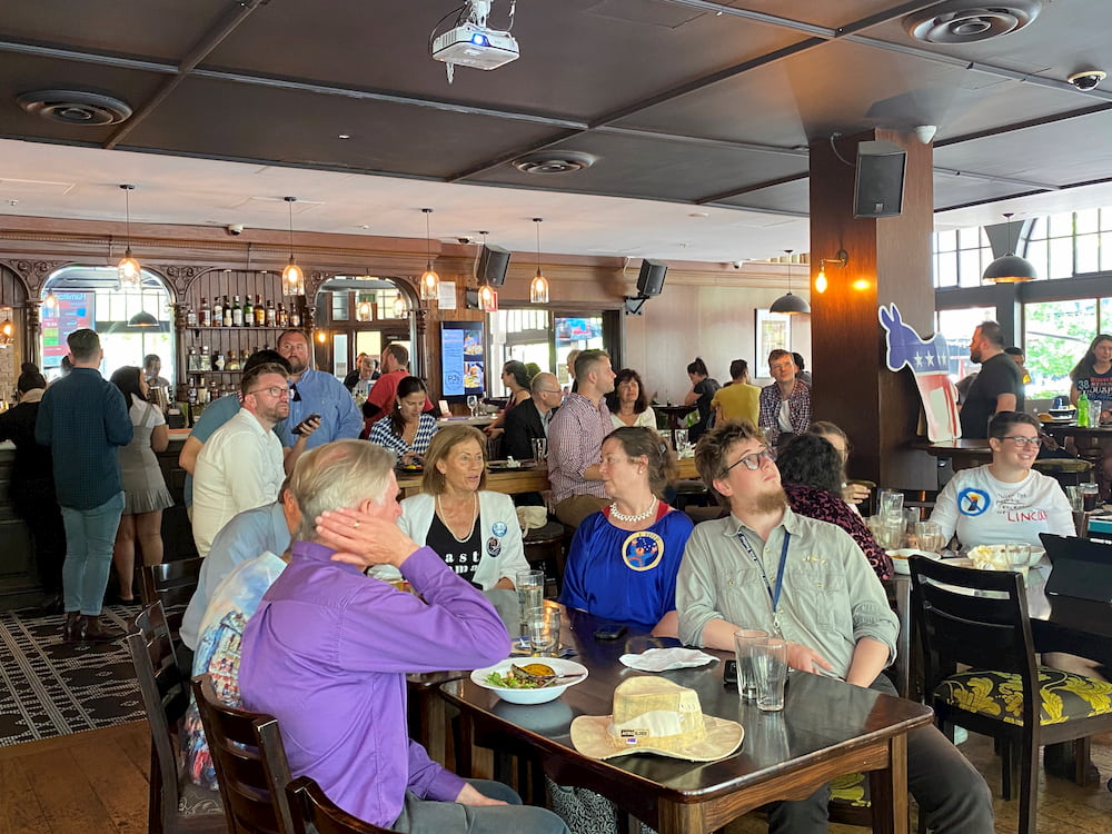 A group of Canberra residents with strong ties to the United States sit watching the presidential race in a pub.