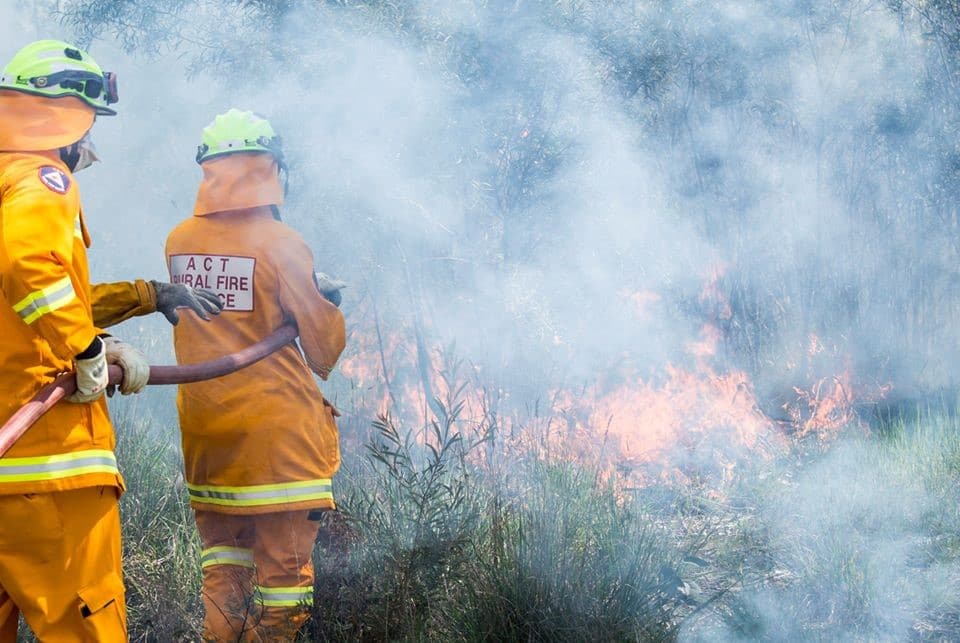 Two ACTRFS volunteers battle flames during last year's bushfire season
