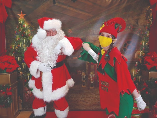santa and an elf touching elbows