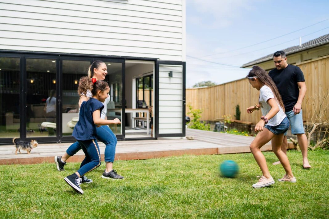 family playing soccer in the backyard