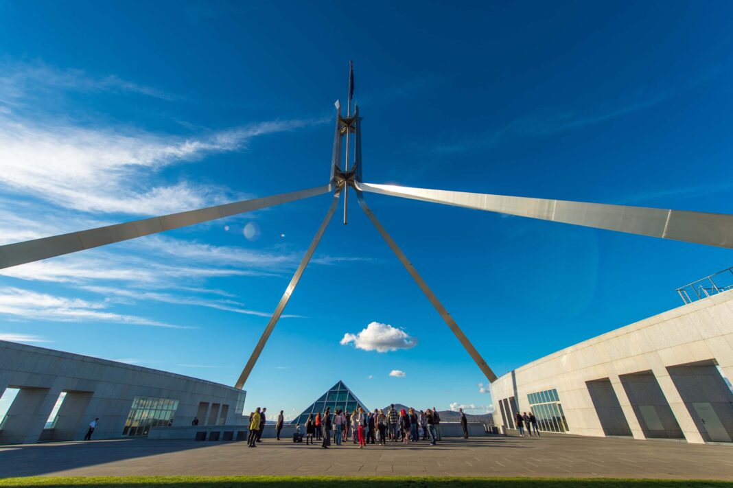 Shot of flagpole at Australian Parliament House looking up towards a blue sky
