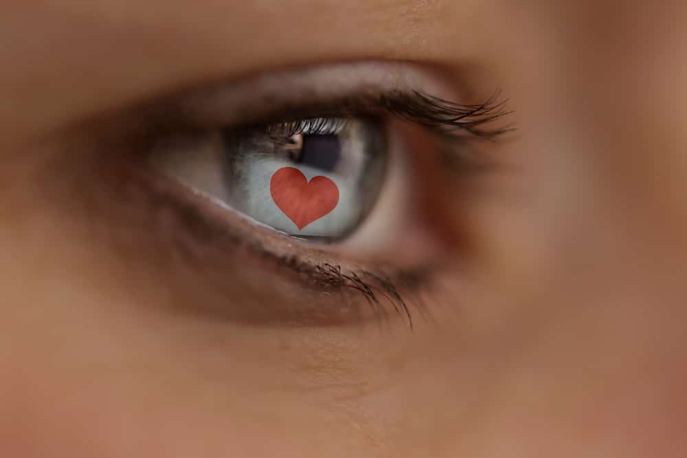 A photo of an eye showing the reflection of a love heart on a computer screen to symbolise online dating