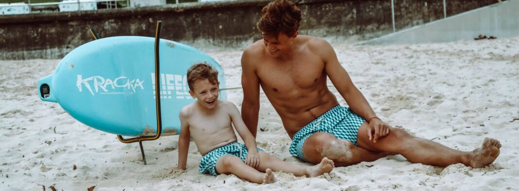 father and son in bondi joe swim trunks on the beach
