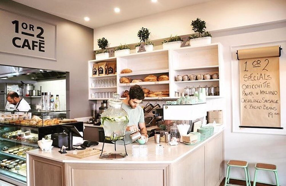 barista making coffee in light and spacious interior of contemporary cafe