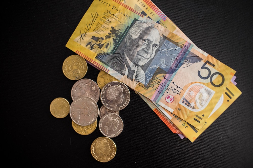 Australian coins and a fifty dollar note lie on a black background, to symbolise the pocket money kids will no longer be able to bank with Dollarmites in ACT.