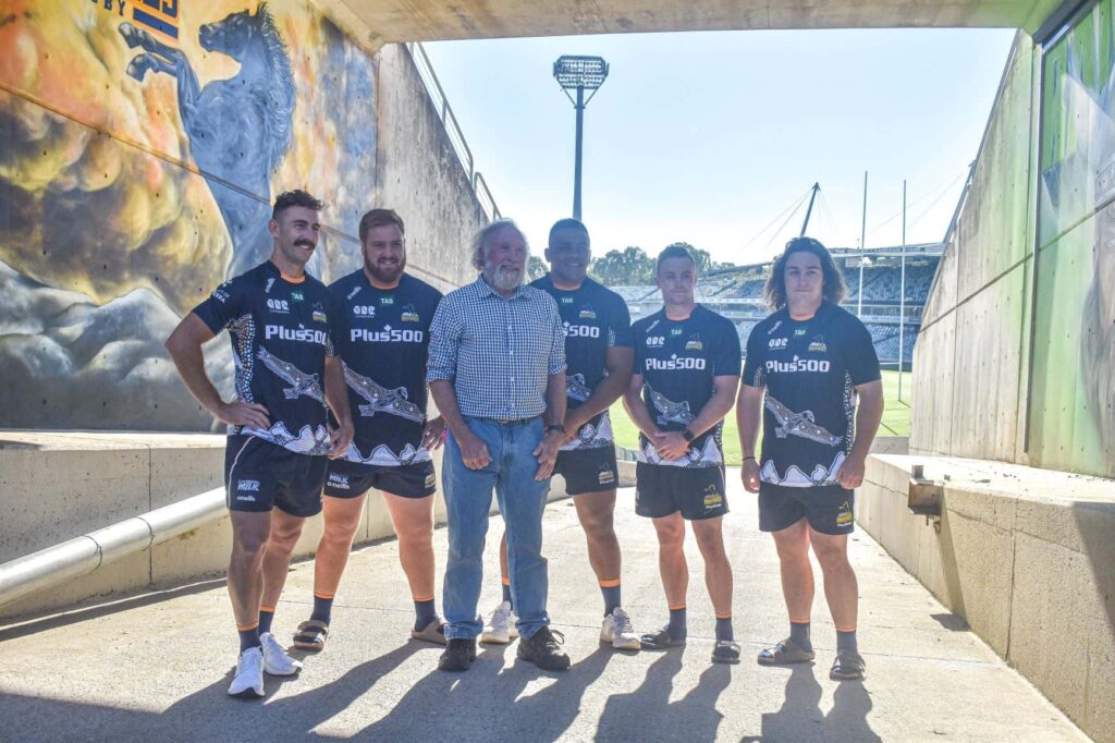 brumbies players and artist in front of new mural