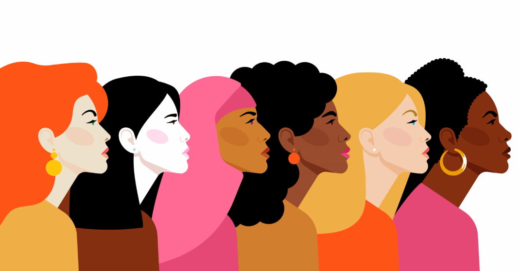 An illustration of women of different ethnic backgrounds stand in a row facing the same direction, for International Women's Day.