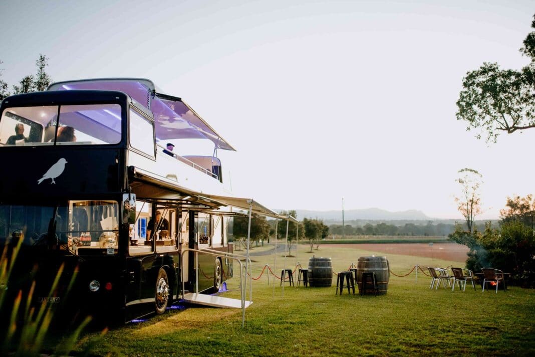 Black double decker pop-up wine and food bus parked at a winery