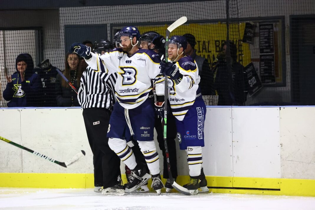 cluster of ice hockey players in dark blue and white CBR Brave uniforms congratulating player who just scored a goal