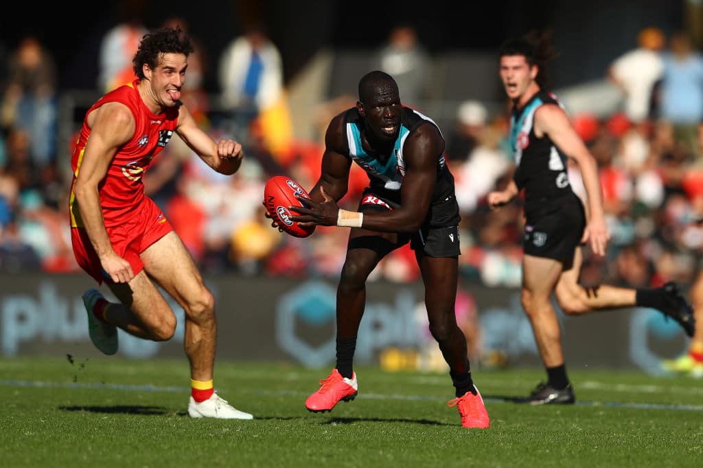 GOLD COAST, AUSTRALIA - JUNE 19: Aliir Aliir of the Power handballs during the round 14 AFL match between the Gold Coast Suns and the Port Adelaide Power at Metricon Stadium on June 19, 2021 in Gold Coast, Australia. (Photo by Chris Hyde/Getty Images)