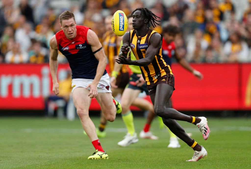 MELBOURNE, AUSTRALIA - APRIL 18: Changkuoth Jiath of the Hawks is chased by Tom McDonald of the Demons during the 2021 AFL Round 05 match between the Hawthorn Hawks and the Melbourne Demons at the Melbourne Cricket Ground on April 18, 2021 in Melbourne, Australia. (Photo by Michael Willson/AFL Photos via Getty Images)