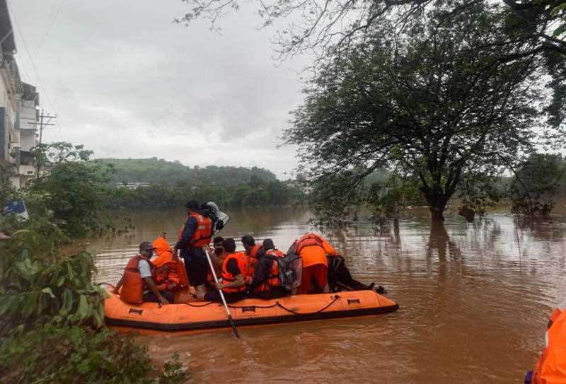 India's National Disaster Response Force personnel in an inflatable boat during a flood rescue operation