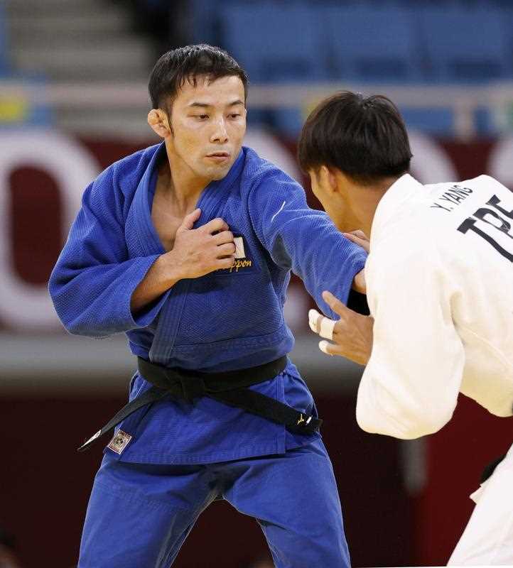 Naohisa Takato (blue) of Japan and Yang Yung-wei of Taiwan compete in the men's judo 60-kilogram final of the Tokyo Olympics