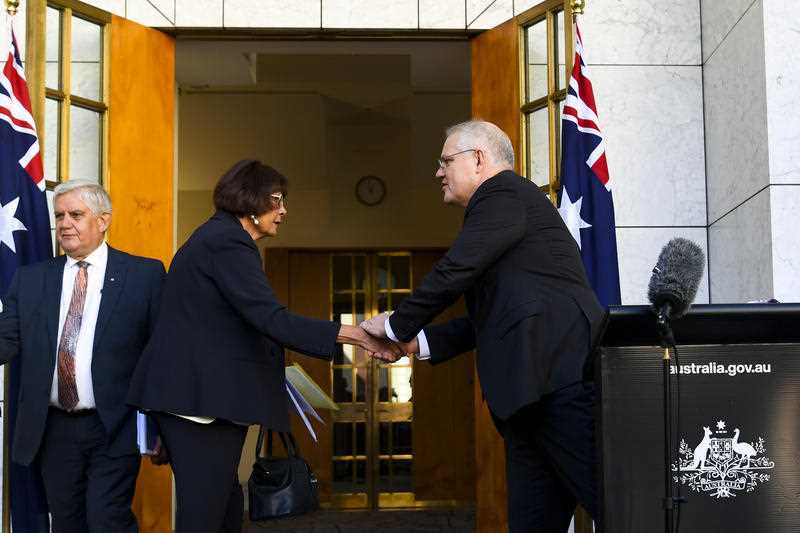 Australian Prime Minister Scott Morrison shakes hands with Coalition of Peaks Convenor and Co-Chair of the Joint Council on Closing the Gap Pat Turner during a press conference at Parliament House in Canberra, Thursday, August 5, 2021.