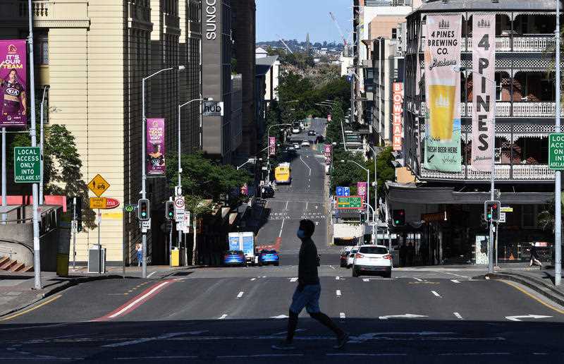 One solo pedestrian crosses a quiet Edward Street in Brisbane CBD on Friday