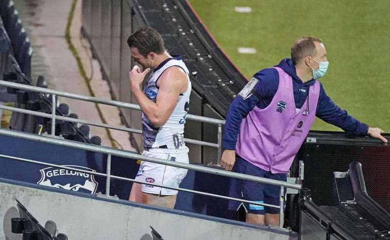 An injured Patrick Dangerfield of the Cats walks to the rooms after being struck by Toby Greene of the Giants during the Round 21 AFL match