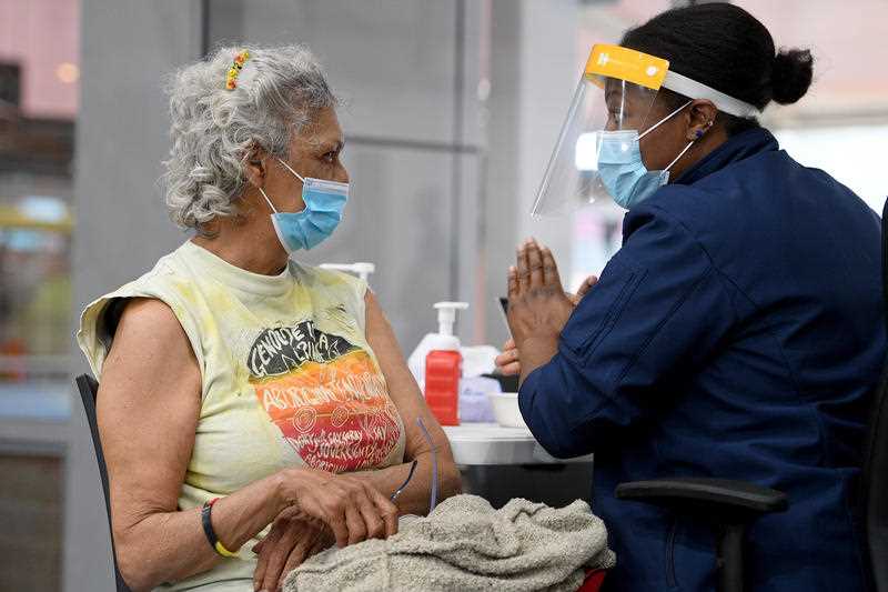 An Aboriginal woman talks to a nurse. Photo: AAP