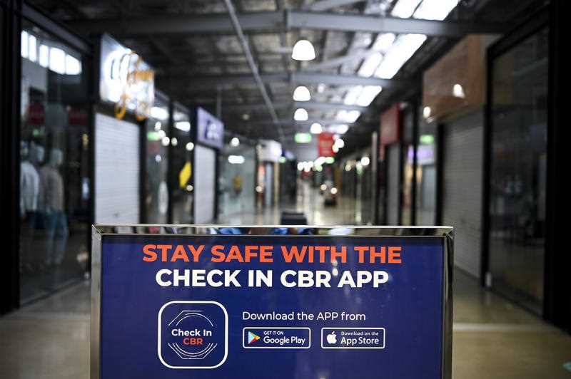 A sign recommends the use of the Check In CBR App at the temporarily closed Canberra Outlet Centre