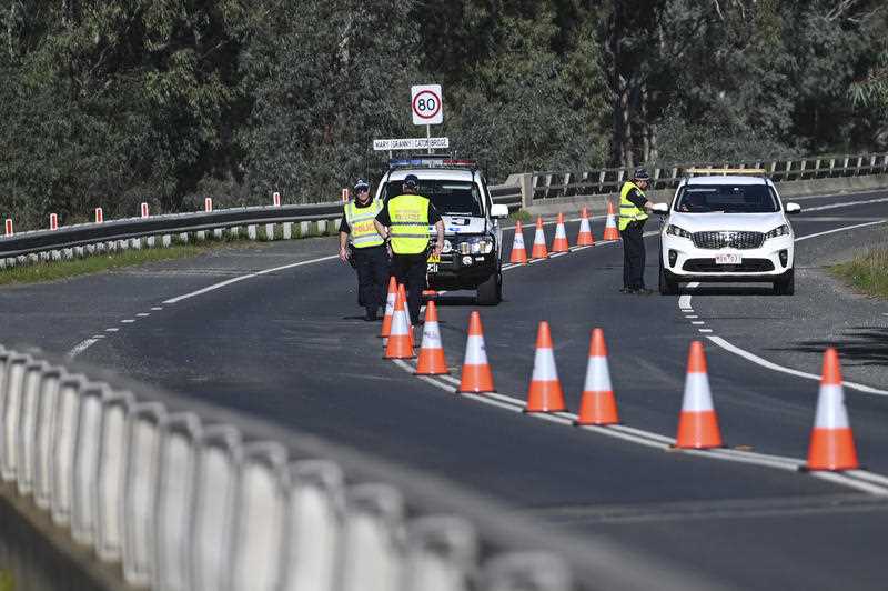 NSW Police officers are seen at the NSW-Victoria border crossing in Howlong near Albury, NSW,