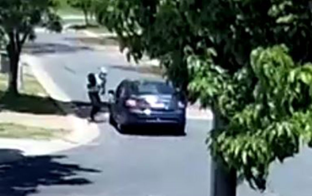 CCTV footage of masked man jumping into a blue Ford Falcon sedan in a Canberra suburban street