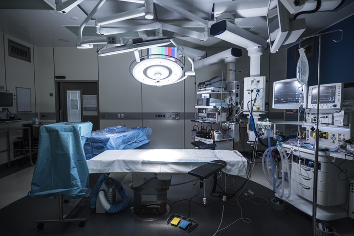 Hospital operating theater with specialist equipment and lighting.