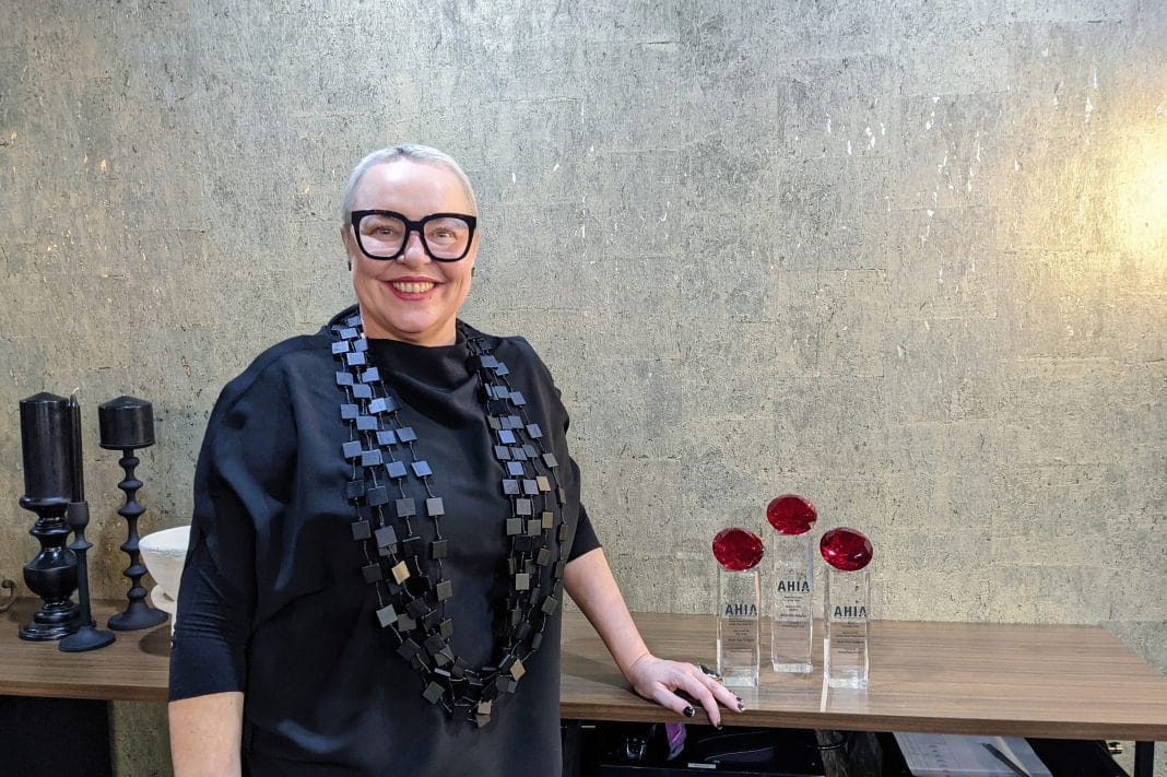 local hair salon owner Jenni Tarrant is seen smiling beside her salon's three awards