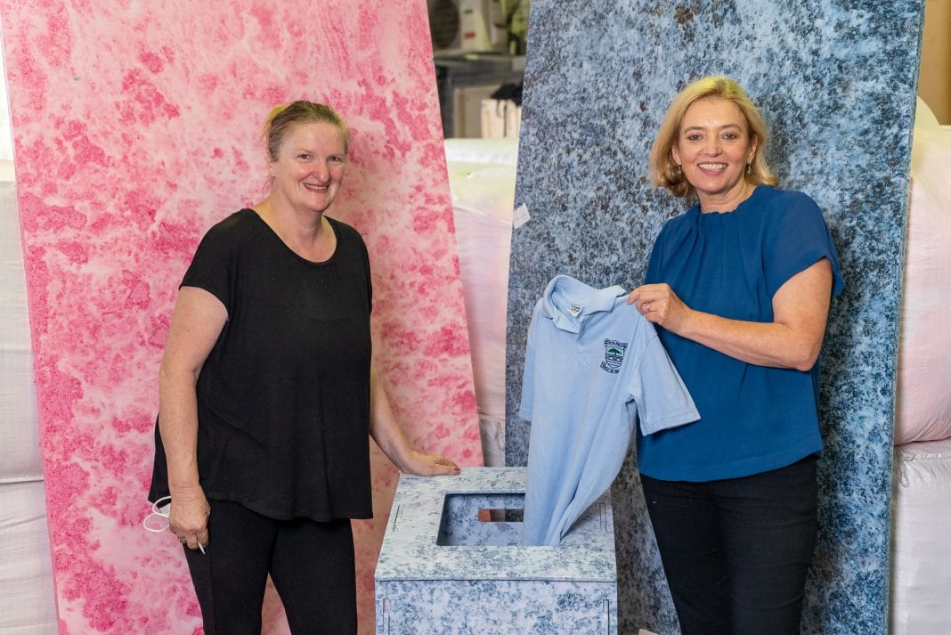 two women with old school uniforms to be recycled into composite furniture