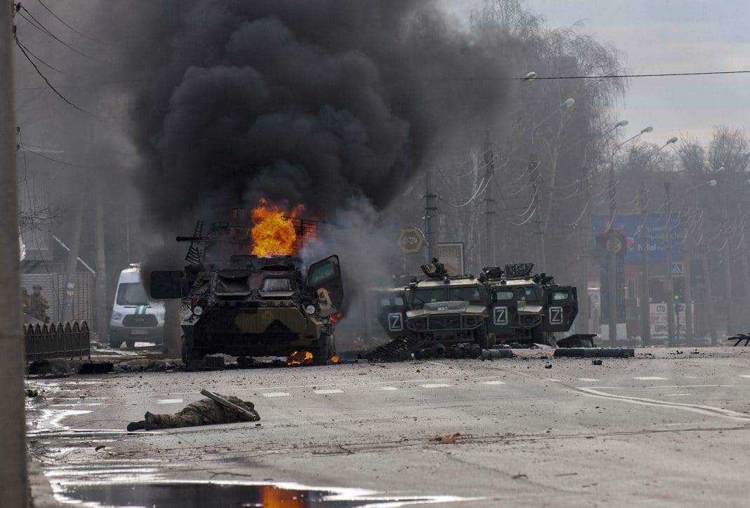 A Russian armored personnel carrier burns amid damaged and abandoned light utility vehicles after fighting in Kharkiv, Ukraine, Sunday, Feb. 27, 2022