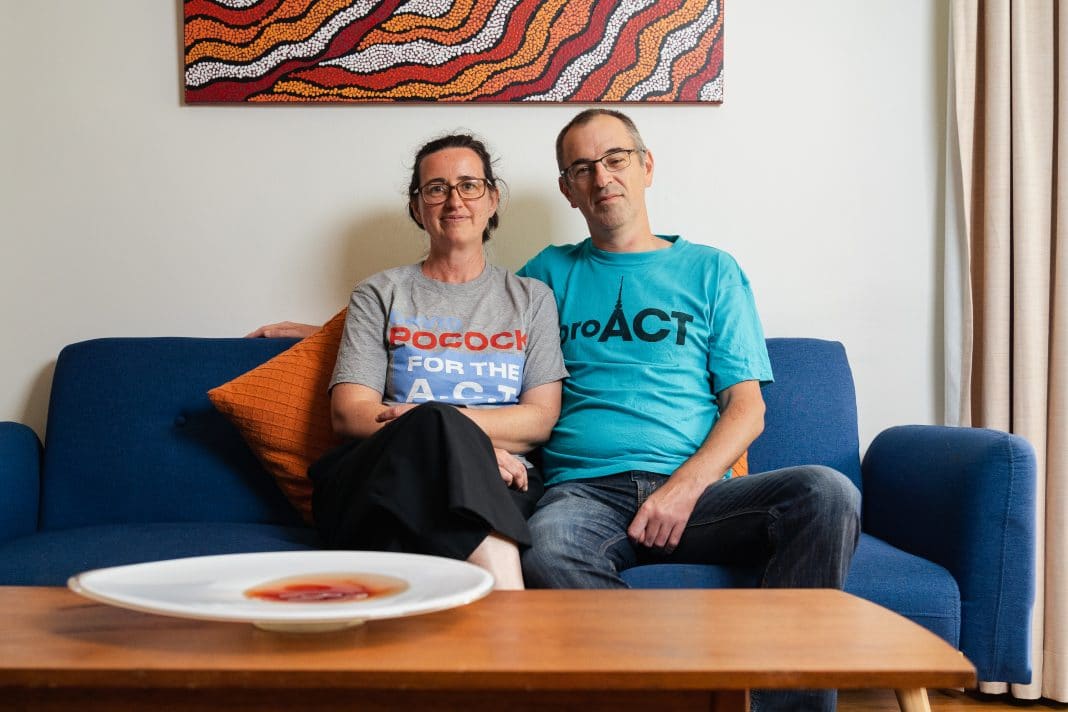 man and woman sitting on sofa smiling