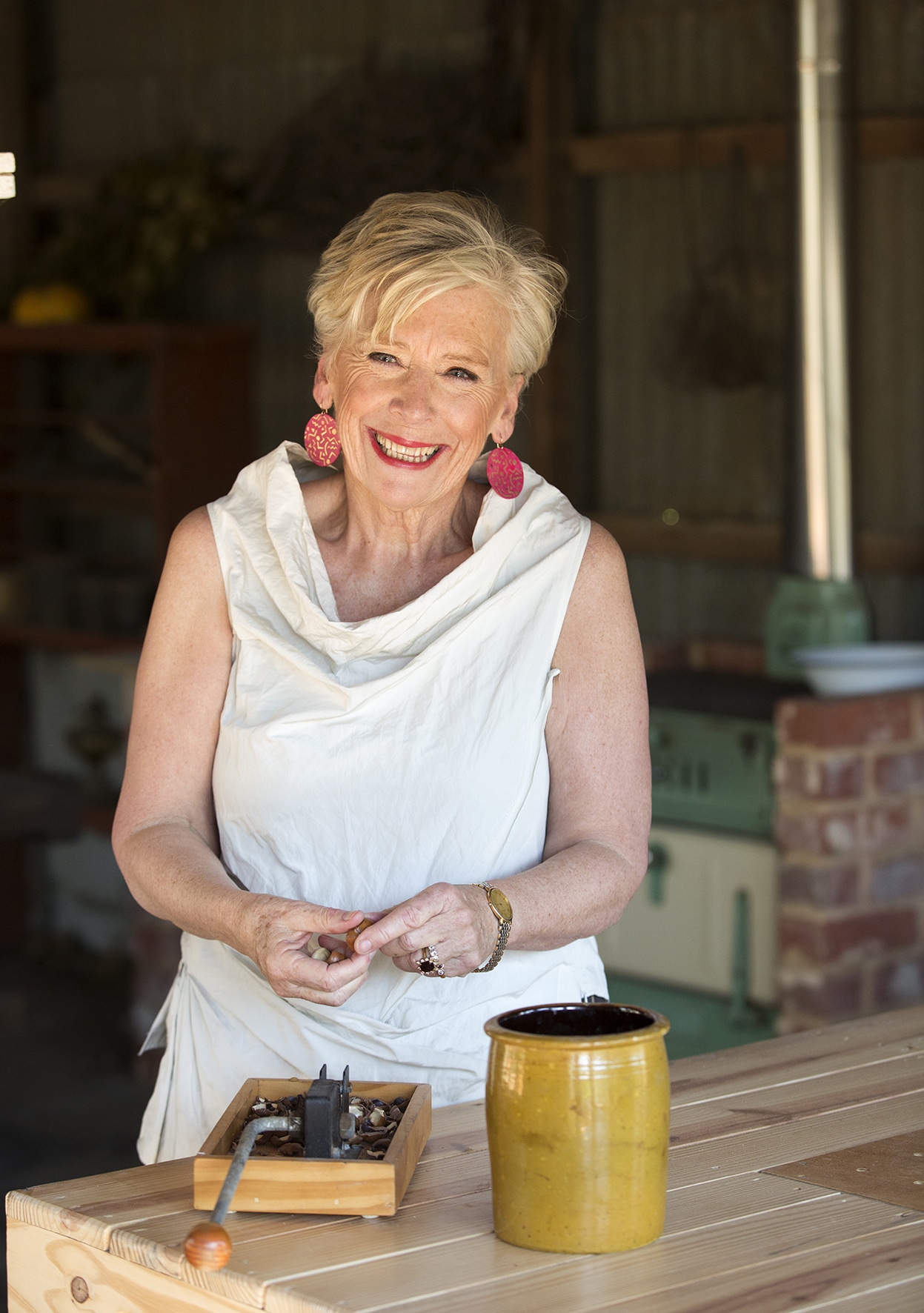 Australian food and TV celebrity Maggie Beer AO is seen shelling nuts and smiling at the camera