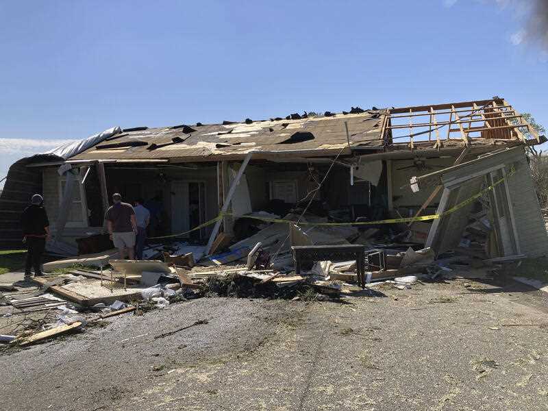 A house that was moved off its foundation during a tornado sits in the street about 30 feet away