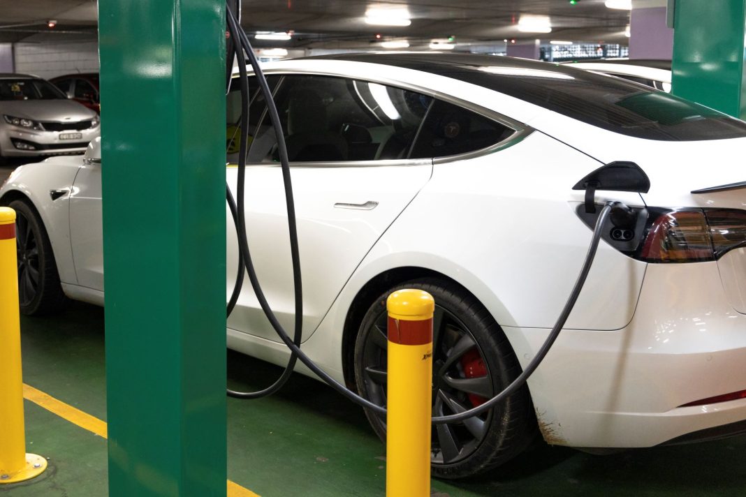 white electric car seen plugged into a charging station in the Canberra Centre carpark
