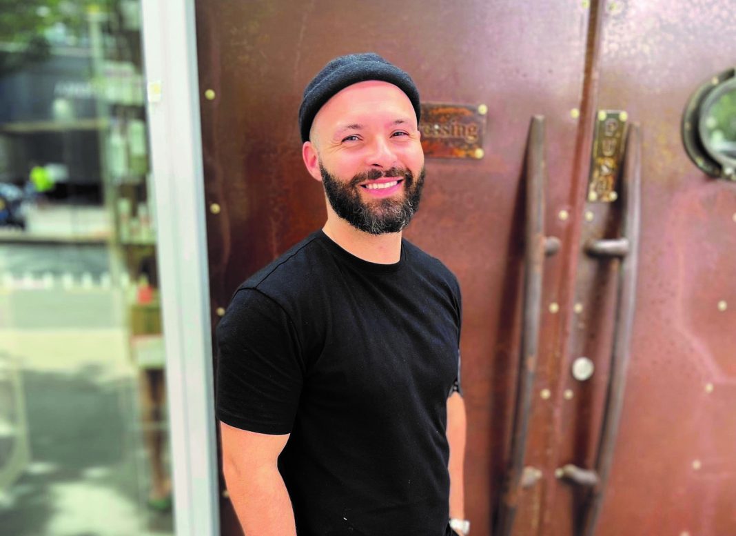 trendy male hairdresser in black t-shirt and beanie