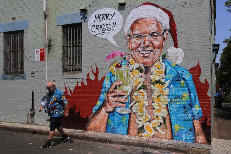 A mural depicting Prime Minister Scott Morrison wearing an unbuttoned Hawaiian shirt, orange lei and Santa Claus hat while holding a cocktail by artist Scott Marsh on a wall in Sydney, Wednesday, December 25, 2019