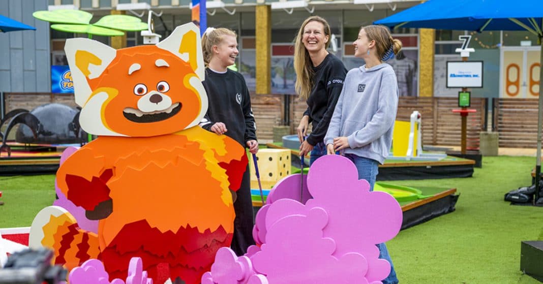 a woman and 2 teenage girls laughing and playing Pixar mini golf in Canberra