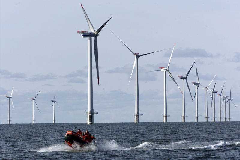 a speed boat passing by offshore windmills in the North Sea