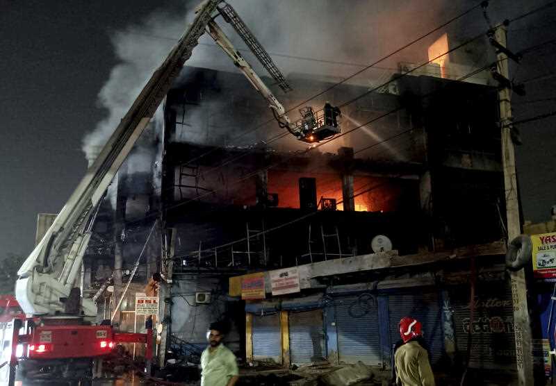 Fire fighters try to douse a fire in a 4-storey building, in New Delhi, India, Friday, May 13, 2022